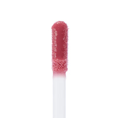 Doe-foot applicator coated in the All Me shade of ColourPop Ultra Glossy Lip, a high-shine rosy pink gloss, shown in an extreme close-up on a white background.