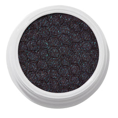 ColourPop Bae Super Shock Shadow shimmering in a white round pot, a deep plum-black cream eyeshadow packed with teal and blue microglitter and a quilted texture, shown close-up on a clean white background.