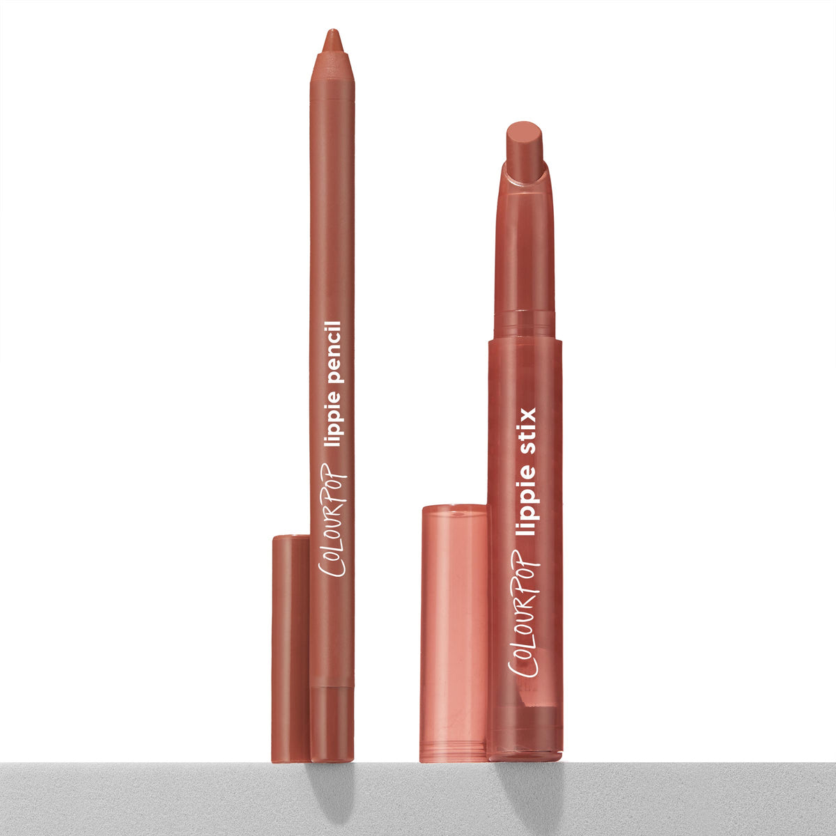 Stripped Down ColourPop Lippie Stix + Pencil Set standing upright with caps off, the rosy nude lippie pencil and slanted-tip lippie stix shown side by side on a light gray ledge against a white background.