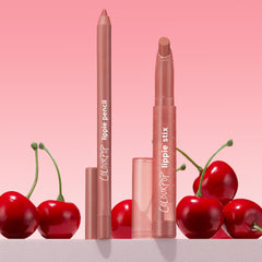 Brink ColourPop Lippie Pencil and Lippie Stix stand upright with caps off, revealing warm rosy nude tips, arranged among glossy cherries on a white surface against a pink gradient background.