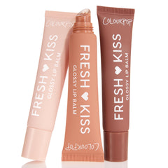 Sweet Treats ColourPop Glossy Lip Balm Trio standing in a fan: three Fresh Kiss squeeze tubes in blush pink, peach, and cocoa, center tube uncapped showing slanted applicator, set against a clean white background.
