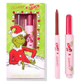 Berry Grinchy So Juicy Plumping Gloss Stick by ColourPop shown with matching lip liner, both in pink tubes, set beside a green ColourPop x The Grinch holiday box featuring the Grinch; berry shade bullet and liner tip visible.
