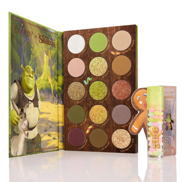 Shrek-Spress Yourself ColourPop Lip and Eye Set featuring an open 16-pan Shrek palette of greens, golds, and browns in matte and shimmer, plus a Candy lip oil with Gingy artwork; displayed upright on a clean white background.