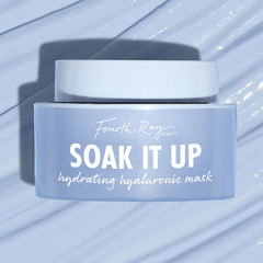 Fourth Ray Beauty Soak It Up Hydrating Mask jar shows “hydrating hyaluronic mask” as it rests on a glossy, water-swept pale blue surface; frosted periwinkle square container with white lid, a ColourPop Face Mask for dewy hydration.