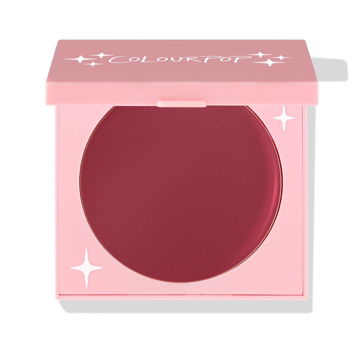 ColourPop Coyote cream blush compact sits half-open, revealing a deep berry pan in a pink square case with white star accents and ColourPop logo; matte cream formula for cheeks; ColourPop Cream Blush on a white background.