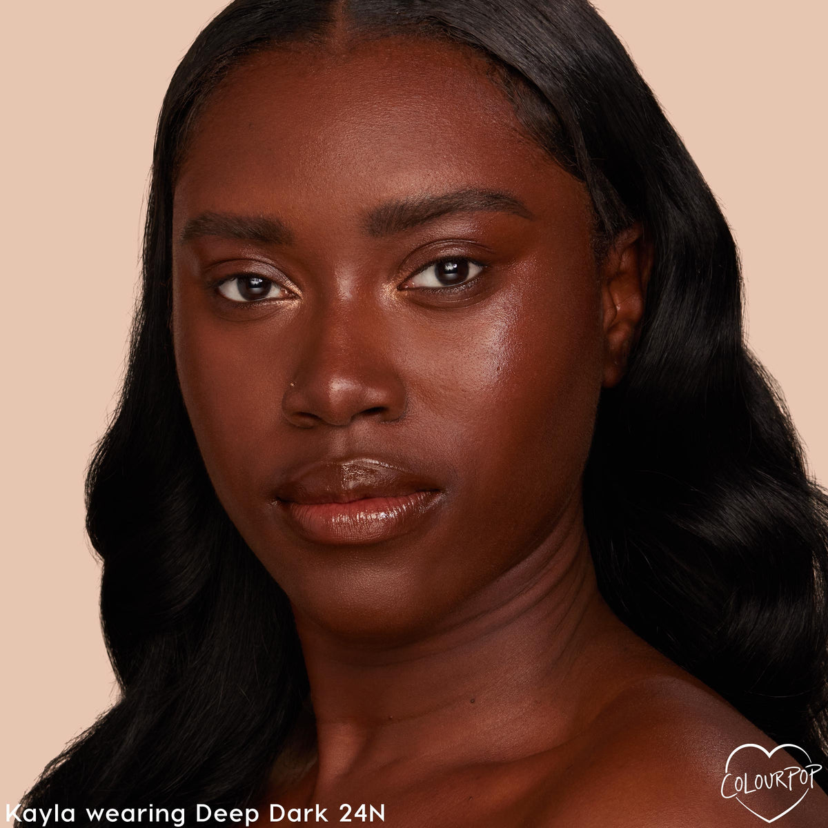 Face wearing ColourPop Pretty Fresh Tinted Moisturizer in Deep Dark 24 N, showcasing a smooth, dewy, even tone with neutral undertones; close-up studio portrait on a soft beige background highlighting shade match and glow.