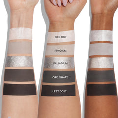 ColourPop Shadow Palette Precious Metals swatched on three arms from light to deep skin tones, showing five shades: Iced Out (pearl shimmer), Rhodium (matte taupe), Palladium (sparkling silver), Ore What? (matte charcoal), Let's Do It (matte black).