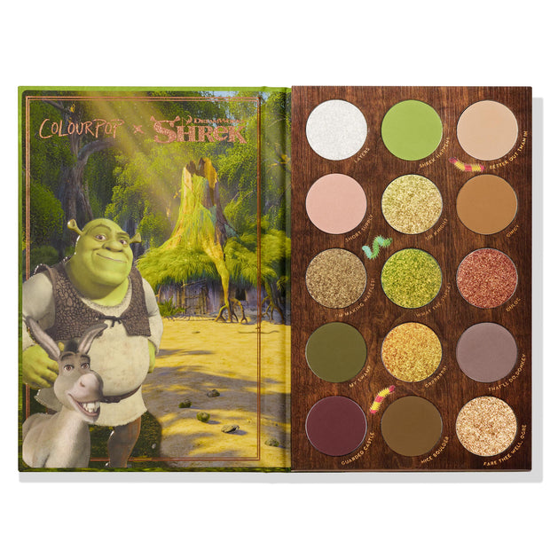 Beware Ogre ColourPop Shadow Palette open, displaying a 3x5 grid of 15 circular shades in swampy greens, golds, browns, and mauves with matte and shimmer finishes in a wood-look tray, beside Shrek and Donkey swamp artwork.