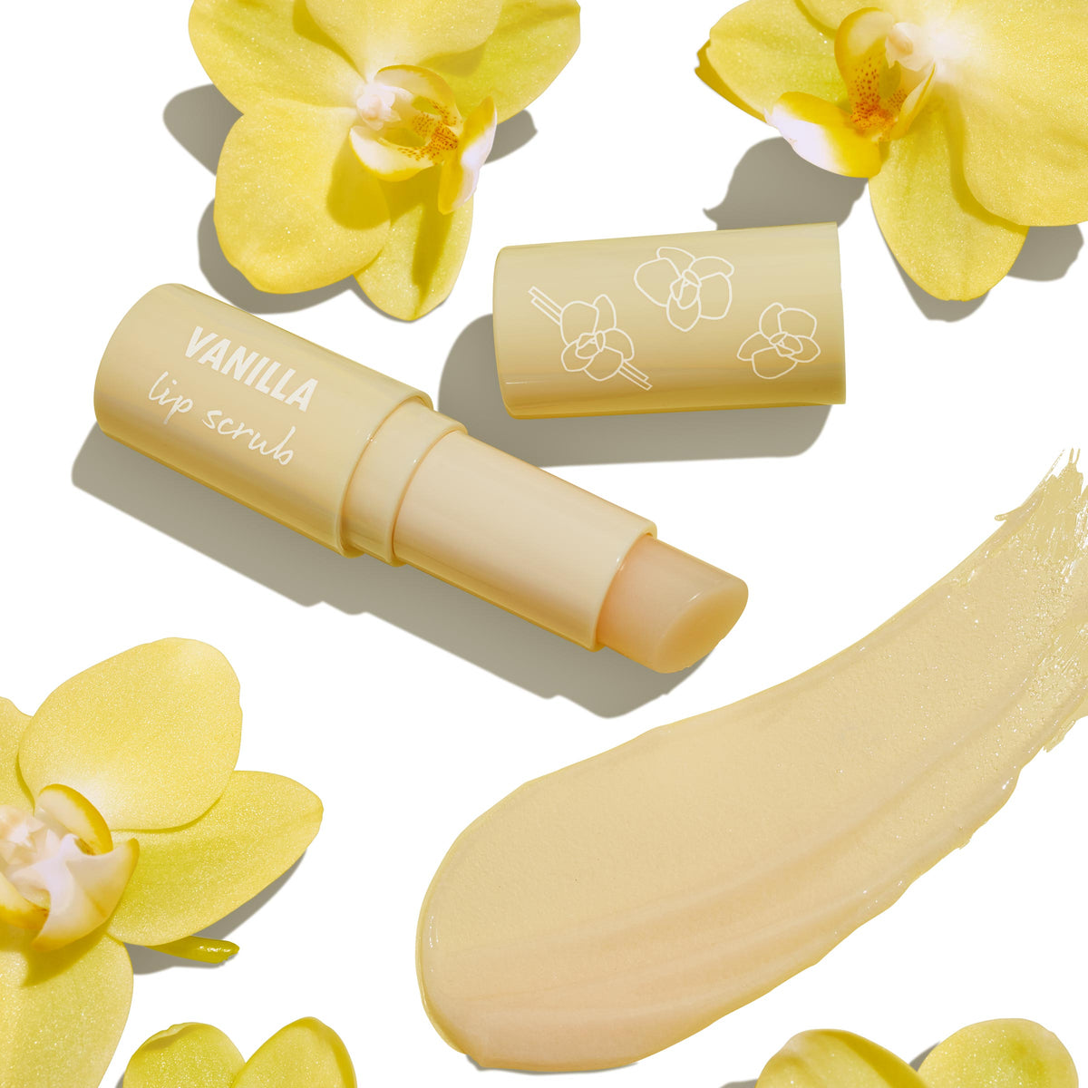 ColourPop Vanilla Lip Scrub stick uncapped to reveal balm, with a creamy vanilla-beige swatch, the cap printed with orchid line art, surrounded by yellow orchid flowers on a clean white background.