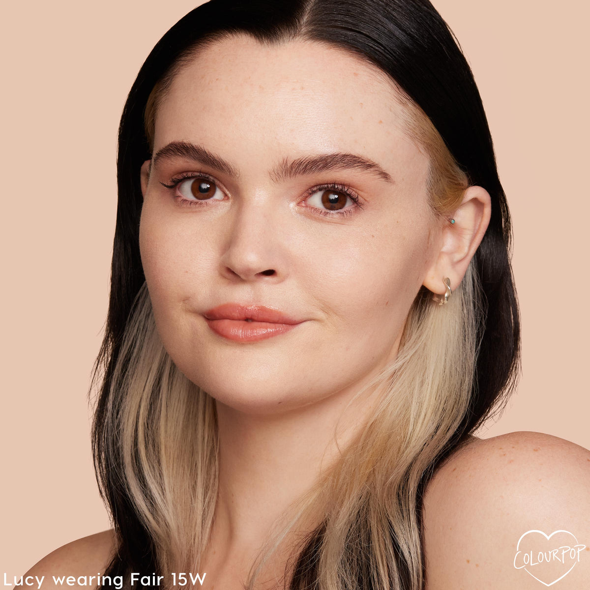 ColourPop Pretty Fresh Creamy Concealer in Fair 15 W smooths and brightens on a model’s face, showing natural dewy coverage; close-up against a peach backdrop highlights the fair warm shade and seamless blend.