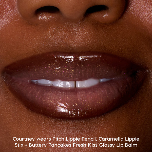 Close-up of glossy, deep brown lips wearing Colourpop Fresh Kiss Glossy Balm in Buttery Pancakes, showing high-shine Lip Gloss & Lip Oil finish with subtle gold shimmer against smooth, warm-toned skin.