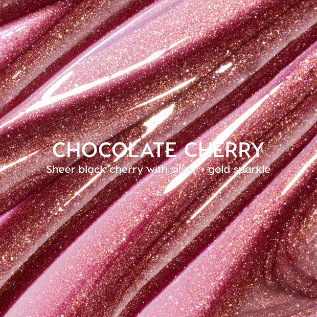 Chocolate Cherry Fresh Kiss Glossy Balm by Colourpop flowing in thick swatches, a sheer black cherry Lip Gloss & Lip Oil shade packed with silver and gold shimmer against a close-up studio background.
