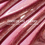Chocolate Cherry Fresh Kiss Glossy Balm by Colourpop flowing in thick swatches, a sheer black cherry Lip Gloss & Lip Oil shade packed with silver and gold shimmer against a close-up studio background.