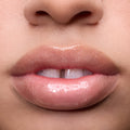 Close-up of models’ lips wearing Colourpop Fresh Kiss Glossy Balm in Whipped Cream, showing sheer nude shine and shimmer finish, highlighting Lip Gloss & Lip Oil texture on different skin tones against a plain background.