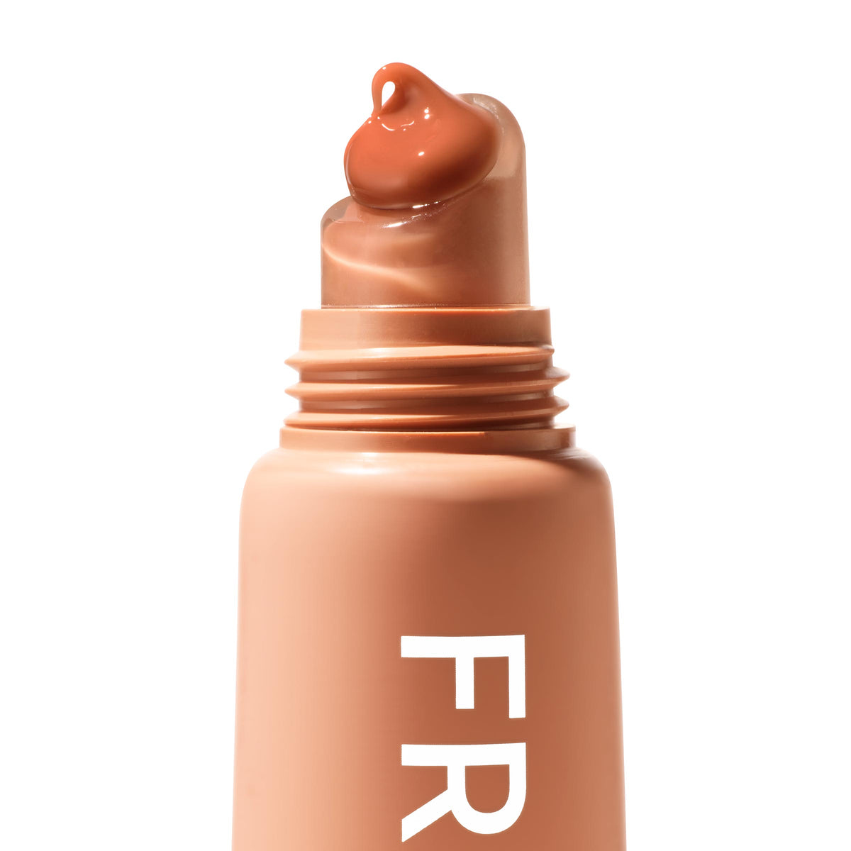 ColourPop Fresh Kiss Glossy Balm in Caramel Latte dispensing a caramel-brown dollop from a slanted rounded applicator tip, shown close-up on a peachy-nude tube with white “FR” lettering against a clean white background.