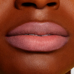 Lips wearing Good N Plenty ColourPop Lippie Pencil, a cool-toned mauve pink liner, filling and defining the lips with a smooth matte finish, shown in a close-up swatch on deep skin for true-to-color payoff.