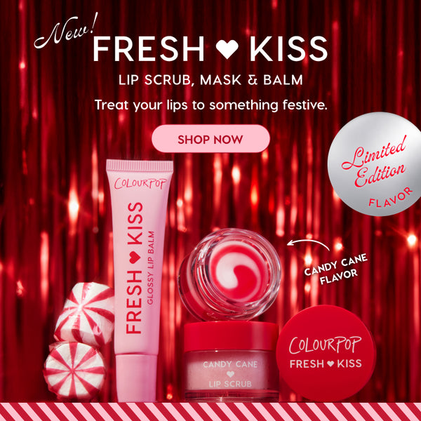 Colourpop Fresh Kiss candy cane lip care set displayed against a red holiday backdrop, featuring glossy lip balm tube, swirled lip mask pot, and candy cane lip scrub jar with cap, styled with peppermint candies, limited edition.