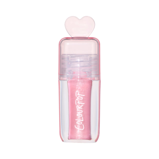 ColourPop 2 Die 4 Ultra Glossy Lip standing upright against a white background, showing its shimmery light pink Heart to Get shade in a clear pink tube topped with a translucent heart-shaped cap for cute, high-shine lip gloss looks.
