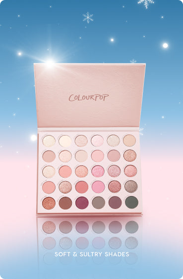 Open Colourpop eyeshadow palette displays 35 soft neutral and pink shades in matte and shimmer finishes, housed in a pastel pink case, set against a blue-to-pink snowy holiday background with snowflakes and the caption Soft & Sultry Shades.