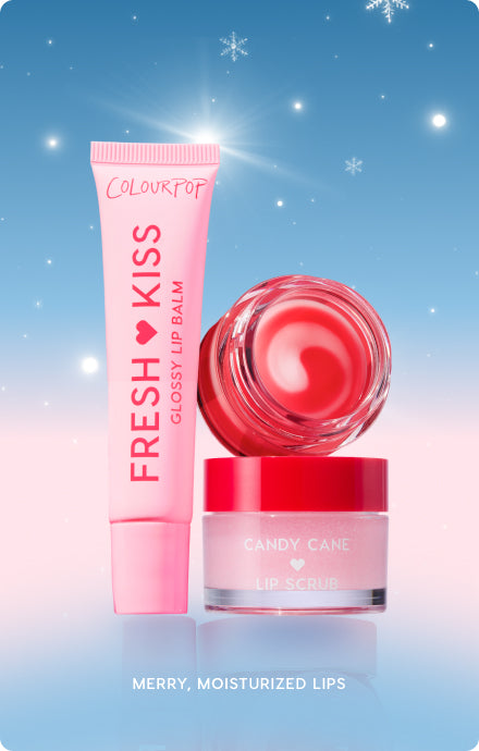 Colourpop lip care trio showcases a pink Fresh Kiss Glossy Lip Balm tube, a red‑swirled balm pot, and a Candy Cane Lip Scrub jar, standing upright against a snowy holiday gradient background to promise merry, moisturized lips.