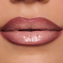 Full lips wear In the Nude Lippie Stix, a ColourPop Lippie Stix shade in pink-beige nude, applied evenly with a glossy satin sheen in a tight studio close-up.