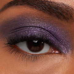 Eye wearing metallic plum-purple shimmer from lash line to brow bone, showcasing ColourPop Jelly Much Shadow in Emo Inside; macro close-up highlights smooth texture, sparkle, and full color payoff on lid with defined lashes.