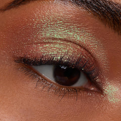 Closed eye wearing ColourPop Jelly Much Shadow in Shiny Penny, a copper metallic with green duochrome shimmer, coating the lid and crease in a smooth, foiled finish to showcase long-wear, high-shine payoff in a macro close-up.