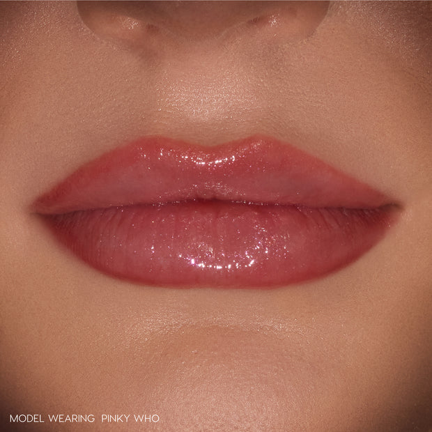 Glossy lips wearing ColourPop So Juicy Plumping Gloss Stick in Pinky Who, delivering sheer rosy pink shine that visibly plumps and smooths the mouth, shown in a tight close-up on natural skin as a beauty swatch.