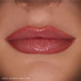 Glossy lips wearing ColourPop So Juicy Plumping Gloss Stick in Pinky Who, delivering sheer rosy pink shine that visibly plumps and smooths the mouth, shown in a tight close-up on natural skin as a beauty swatch.
