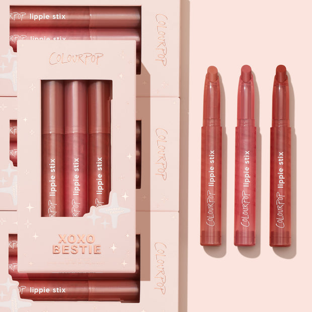Three lipstick sticks inside and outside of their pink packaging