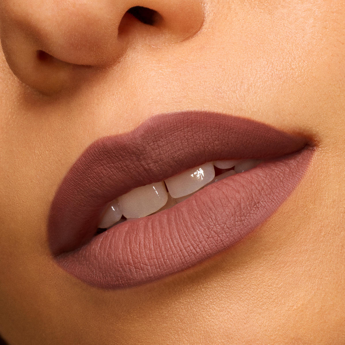 Matte mauve lips wearing Bella! Where the Hell Have You Been, Loca? Power Pout Lipstick, showing full, velvety coverage with defined edges, captured in an extreme close-up on warm skin - ideal for completing a ColourPop Lip Set.