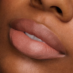 Full lips wearing ColourPop Power Pout Lipstick, Bella! Where the Hell Have You Been, Loca?, showcasing a creamy nude-rose shade with a soft-matte finish in a studio close-up, emphasizing smooth texture, precise edges, and full-coverage payoff.