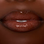 Glossy lips wearing ColourPop Ultra Glossy Lip in Coffee Break, a rich coffee‑brown creme shade, reflecting high shine in a tight close-up studio shot.