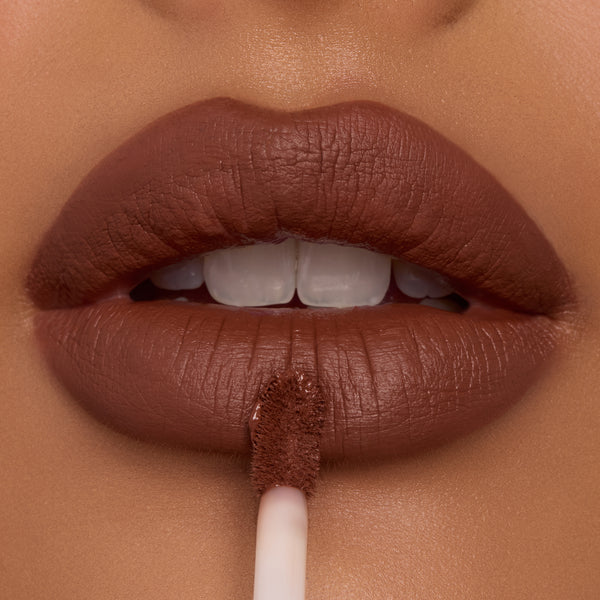 Full lips apply Espresso Martini Ultra Blotted Lip with a doe-foot applicator, revealing a soft-matte, blurred finish in a rich cocoa-brown shade; close-up of ColourPop Ultra Blotted Lip on warm skin.