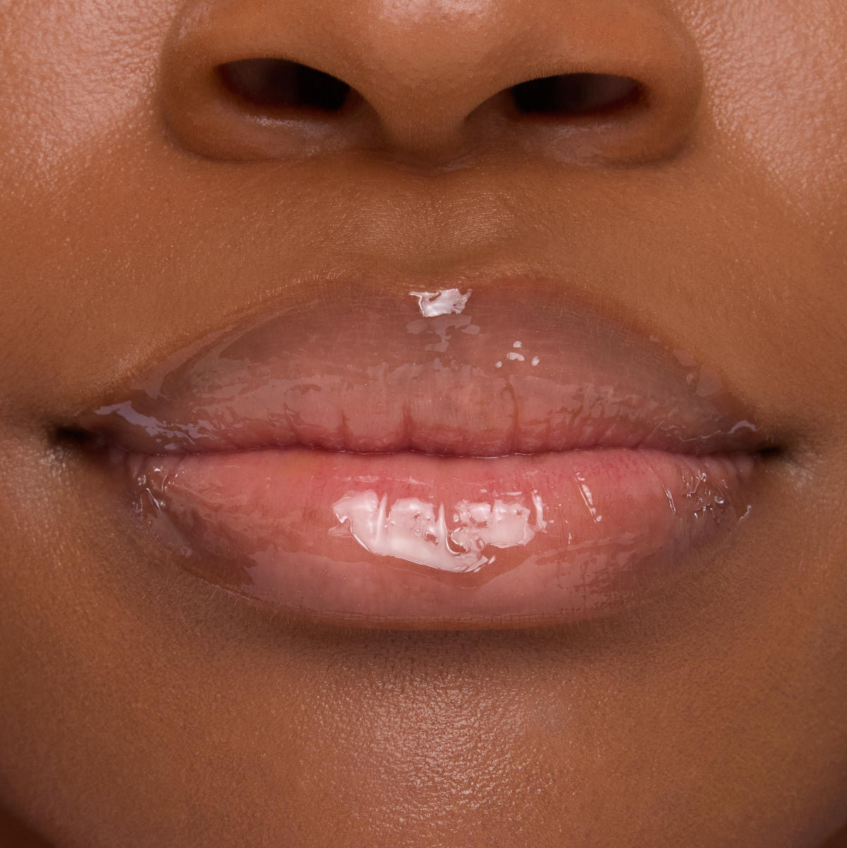 Lips wearing ColourPop Lip Mask in Strawberry Milk, gleaming with a sheer pink, high-shine finish in a tight close-up that emphasizes smooth, hydrated texture.