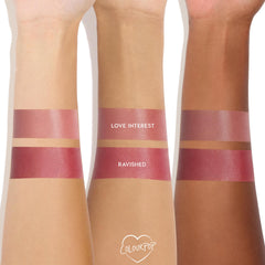 Ravished Lip and Cheek Balm swatched in wide bands on three arms of light, medium, and deep skin tones, showing a glossy berry-rose pigment beneath a lighter Love Interest swatch; creamy, buildable ColourPop Lip and Cheek Balm finish.