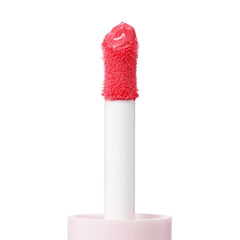 Doe-foot applicator coated in Angel Face ColourPop Liquid Blush, a vibrant pink shade, shown in a macro close-up on a white background, highlighting the plush wand texture, white stem, and pale pink cap.