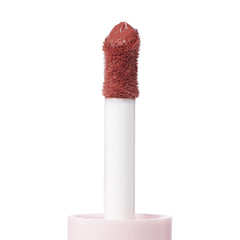 Doe-foot applicator coated in the creamy rosy-nude Culver City shade of ColourPop Liquid Blush, shown in macro close-up with a plush flocked tip rising from a soft pink tube against a clean white background.