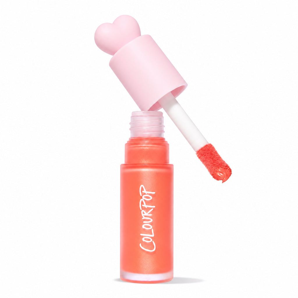 ColourPop Liquid Blush in Perfect Peach, doe-foot applicator lifting from a frosted coral tube with a pink heart-shaped cap, revealing a warm peachy tint; Allure 2025 Best of Beauty badge on a clean white background.