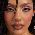 Model showcasing Smoke 'N Roses shades from the ColourPop Shadow Palette, wearing shimmery rose and mauve smoky eyes with sharp black winged liner, inner-corner pink highlight, dewy skin, rosy blush, and glossy nude lips in a tight face close-up.