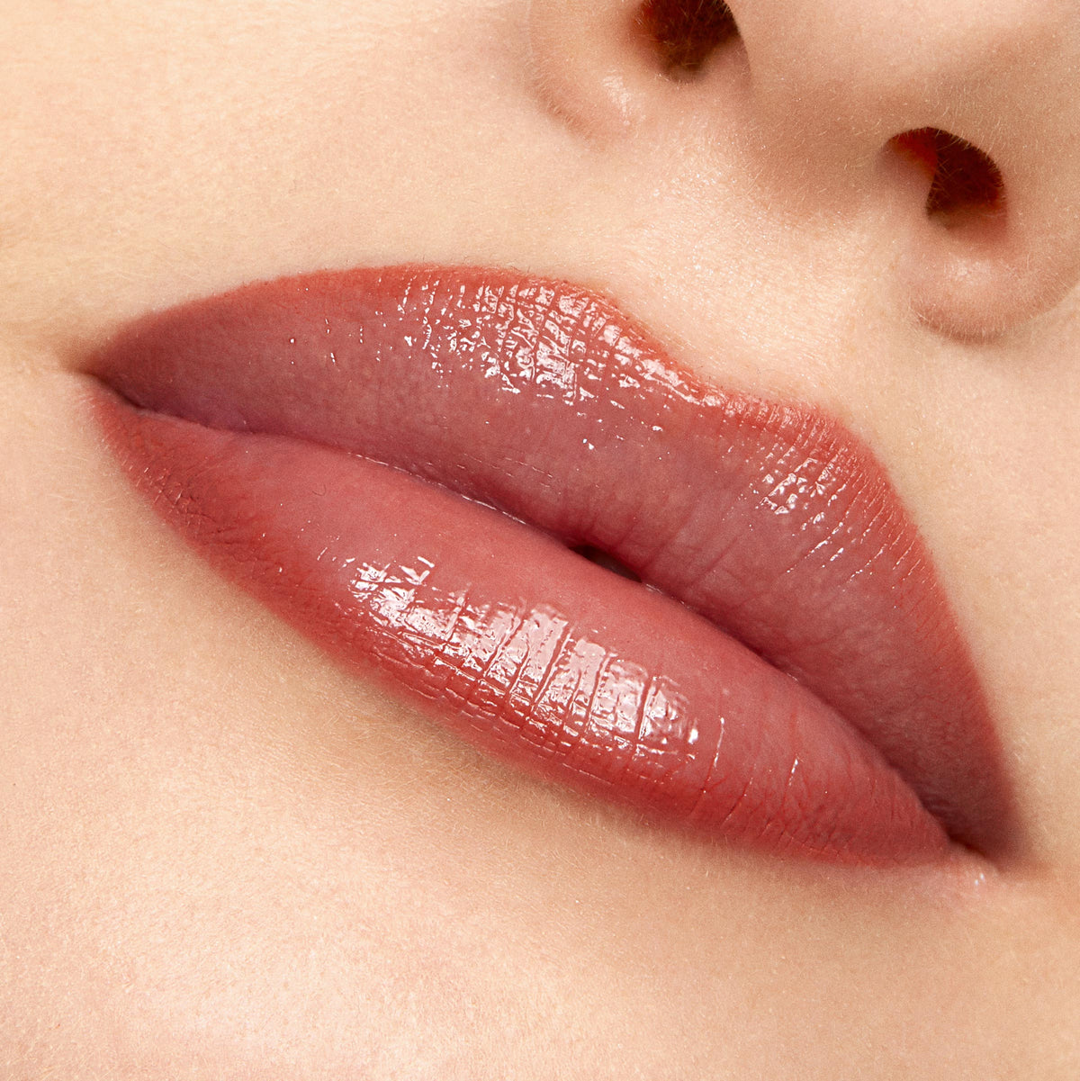 Glossy lips lined and softly filled with Oh Sis, a neutral rosy-brown ColourPop Lippie Pencil, creating smooth, defined edges in a tight close-up beauty shot of the mouth and nose area.