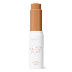 ColourPop Pretty Fresh Tinted Foundation Balm in Dark 17, open twist-up stick showing a warm deep tan shade, standing upright in a white tube with peach “Pretty Fresh” lettering on a clean white background.