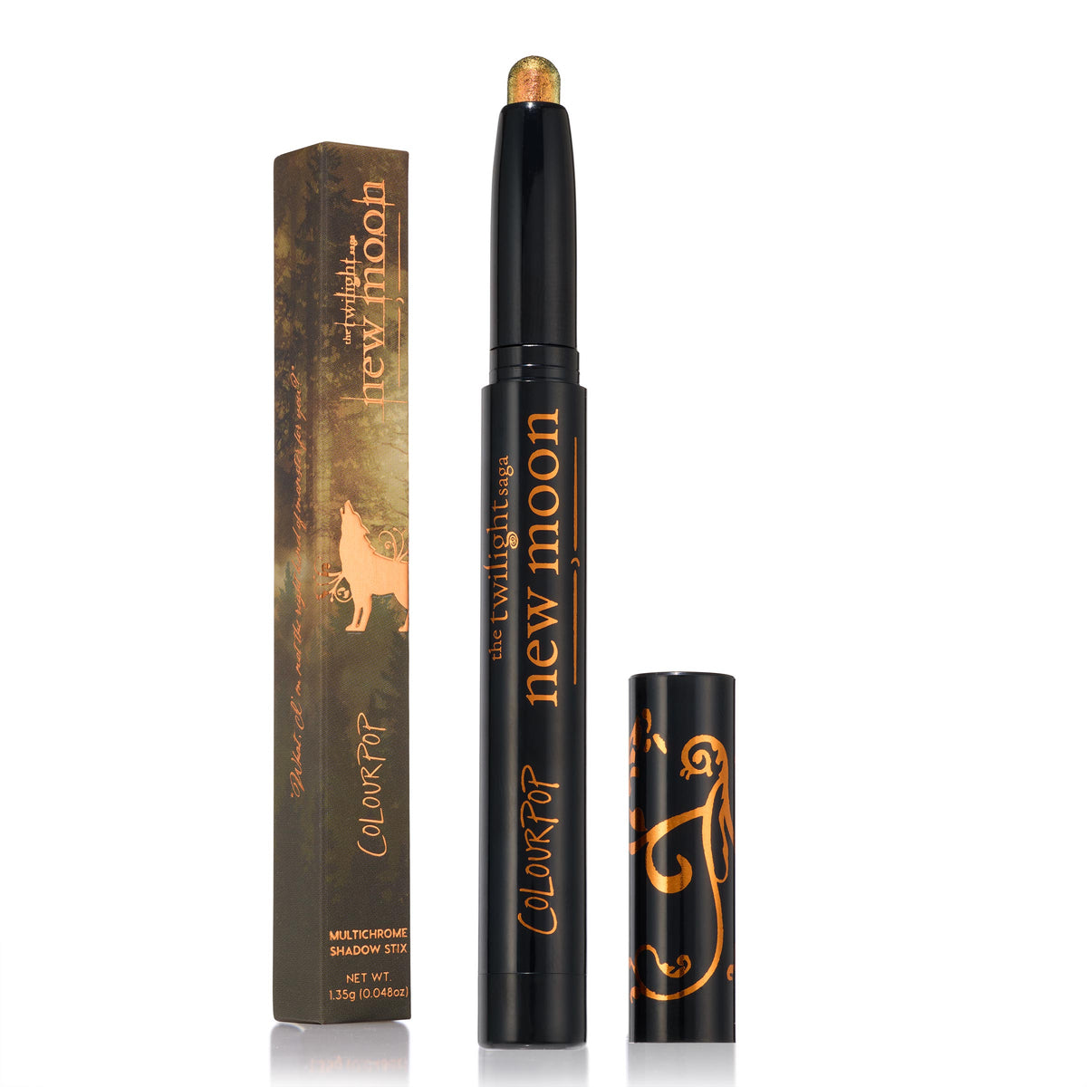 ColourPop Shadow Stix Wolf Girl multichrome eye crayon stands uncapped to reveal a golden‑olive shift tip, the sleek black tube featuring copper New Moon Twilight graphics, with cap and wolf‑themed box beside on a white background.