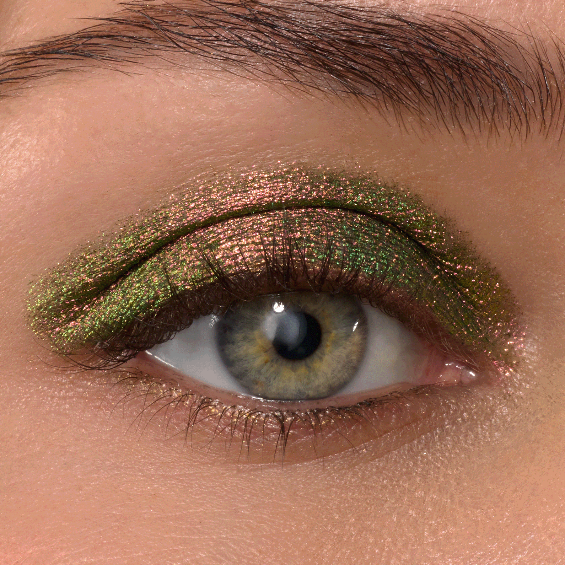Multichrome eyeshadow shifts olive green to rosy copper on a single eyelid, showcasing It’s Always Been Him Shadow Stix, a ColourPop Shadow Stix, delivering smooth metallic payoff with a precise swipe, captured in a close-up under studio lighting.