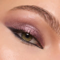 Shimmering mauve-plum eyeshadow coats the lid and blends to a soft smoky wing, showcasing the creamy, high-shine finish of ColourPop Shadow Stix in Next Spot in a macro close-up of one eye with defined lashes and brow.