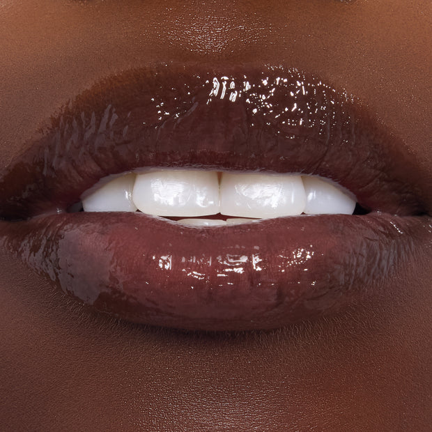 Glistening lips wear Gumdrop Buttons, a rich cocoa-brown ColourPop Candy Lip Oil, showing high-shine, smooth hydration and semi-sheer pigment in a close-up beauty swatch.