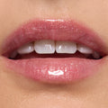 Glossy lips wearing ColourPop Ultra Glossy Lip in Totally Swamped, a sheer pink shimmer with fine sparkle, reflecting high shine in a studio close-up to showcase the smooth, hydrated finish.