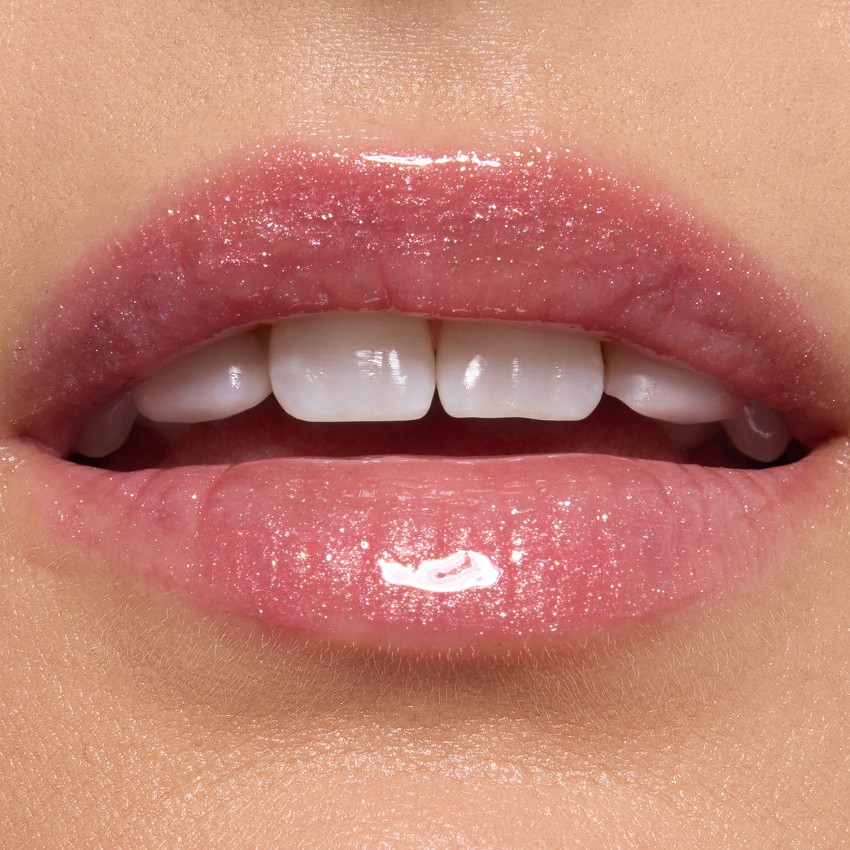Glossy lips wearing ColourPop Ultra Glossy Lip in Totally Swamped, a sheer pink shimmer with fine sparkle, reflecting high shine in a studio close-up to showcase the smooth, hydrated finish.