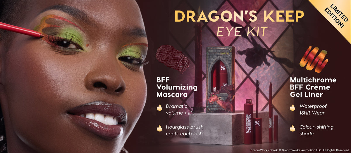 ColourPop Dragon’s Keep Eye Kit featuring BFF Volumizing Mascara and Multichrome BFF Crème Gel Liner as a model traces bold dragon‑scale eyeliner over lime shadow; red Shrek‑branded tubes rest on a stone pedestal before a stained‑glass window.