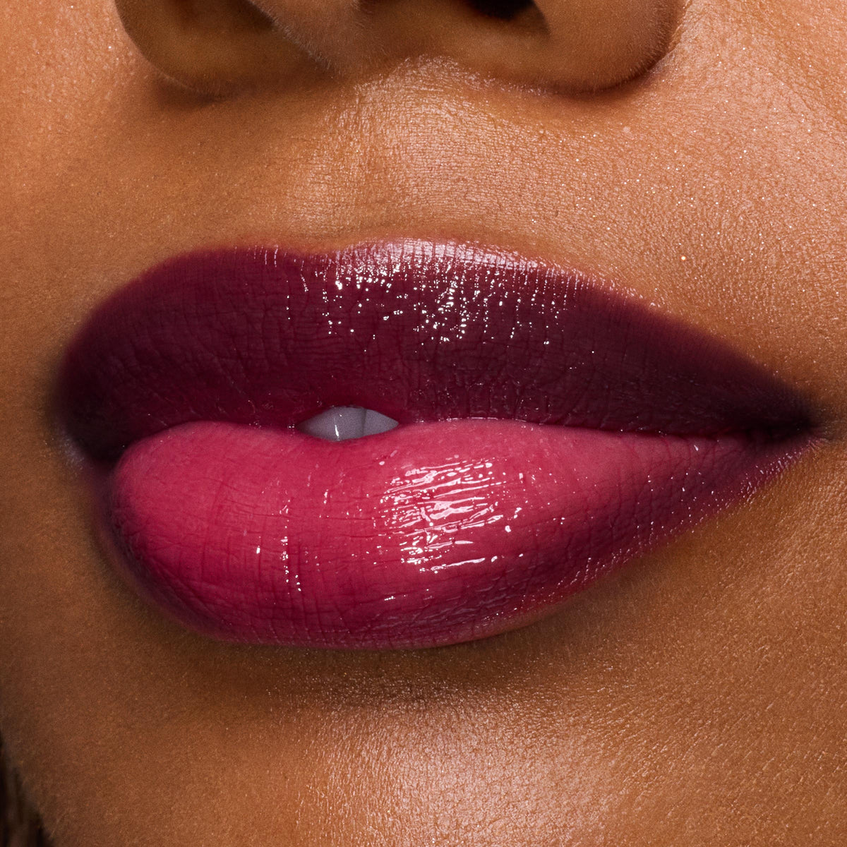 Glossy lips wearing ColourPop So Juicy Plumping Gloss in Temptation, showcasing a deep berry‑pink ombré shine and glassy, plumped finish in a tight close-up beauty shot.